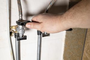 Hand installs water stop tap